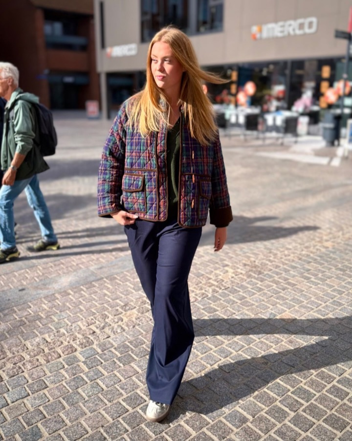 Kvinde i quiltet ternet jakke går gennem gågaden i Holstebro